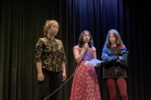 Iris Chen, Aditi Halpe, and Hannah Prokup introduce the fundraising efforts for Ukraine at the student-led International Day assembly on March 24. 
