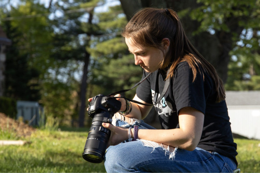 Senior Kai Lincke adjusts her camera settings while taking pictures at the Spring Fling on April 29.