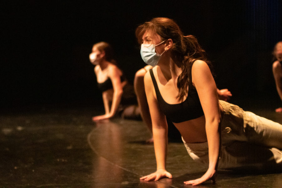 Senior Bella Emmanouilidies, one of the Dance Haven leaders, leans towards the center of the stage during original student choreography at the fall Dance Haven concert.