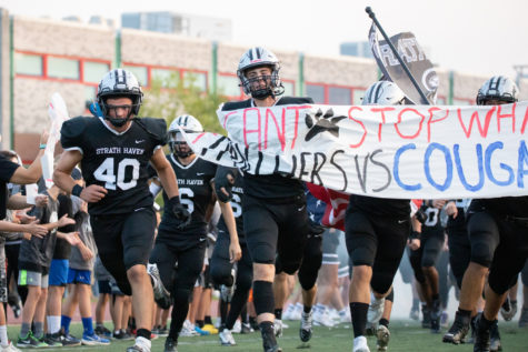 The football team makes their way through the cheerleaders sign, making themselves known to George L. King field on September 16.