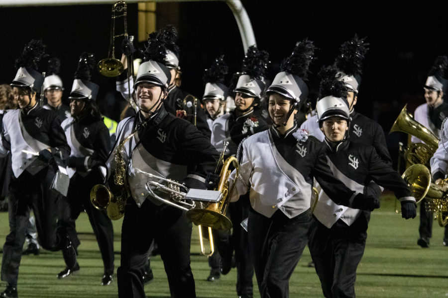 Junior section leader Aiden Gold and senior student director Jess Farhat do their fun run onto the field before the half time show on October 21.