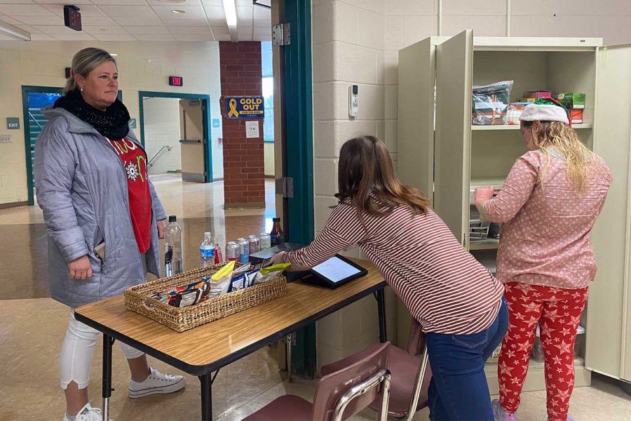 AT YOUR SERVICE • Students serve English teacher Mrs. Kate Evans at the walk-up Panther Cafe on the third floor during fourth block on Monday, Dec. 12. Teachers can purchase items at the cafe in-person or order delivery to classrooms.