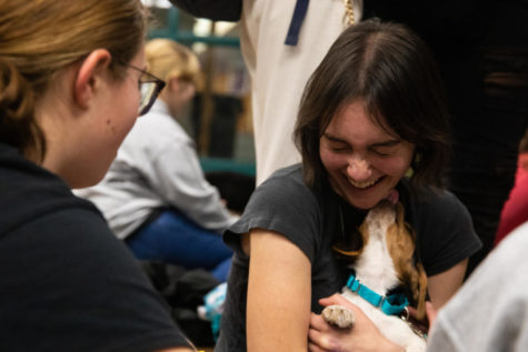 Sophomore Anya Agha laughs as a puppy licks her face. 