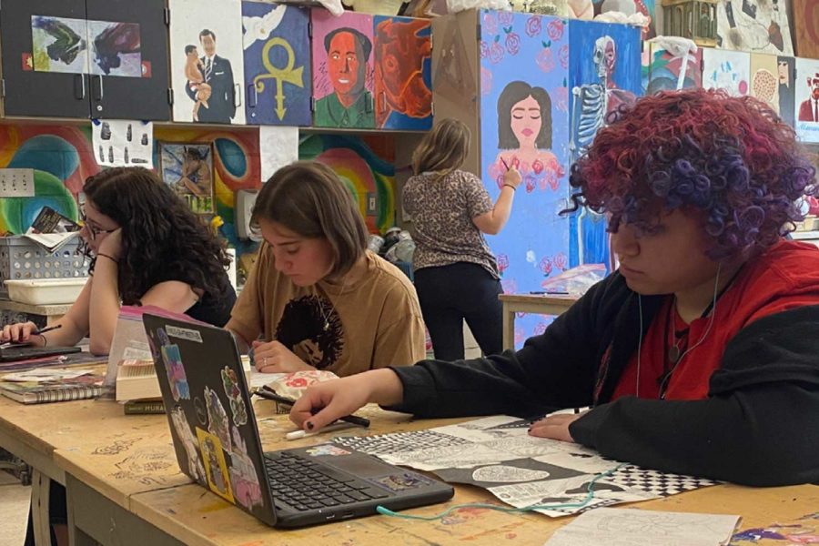 Freshmen Pearl Tweedy and Josie Wieland work on artwork during art class. 