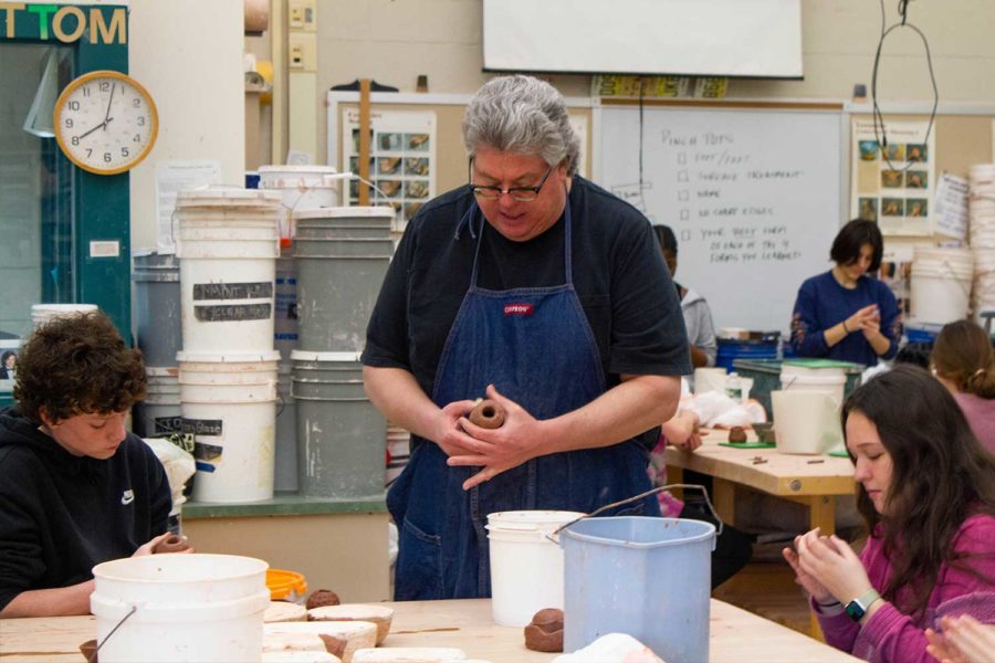 Ceramics teacher Mr. Rogers instructs students on how to make pots by hand. 