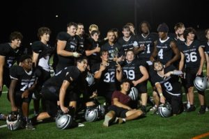 The football team takes a photo with their old coach Erik Hollingsworth, who currently coaches for Ridley after coached at Haven for years prior.