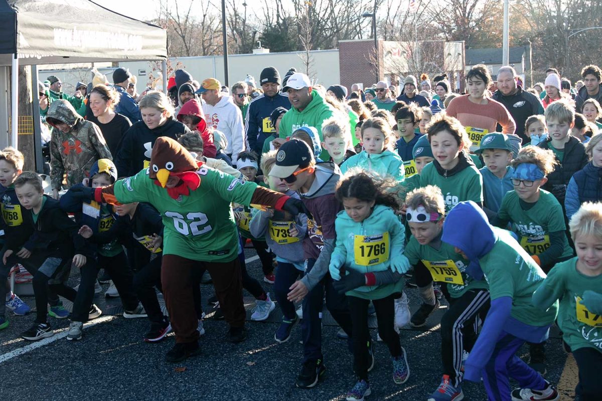 Tom the Turkey mascot holds the crowd of kids back as they launch themselves forward in the Little Drumsticks run on November 23, 2023 at NPE. The event had 2 runs, one for families’ and their
young kids, and one for the official 5K participants.