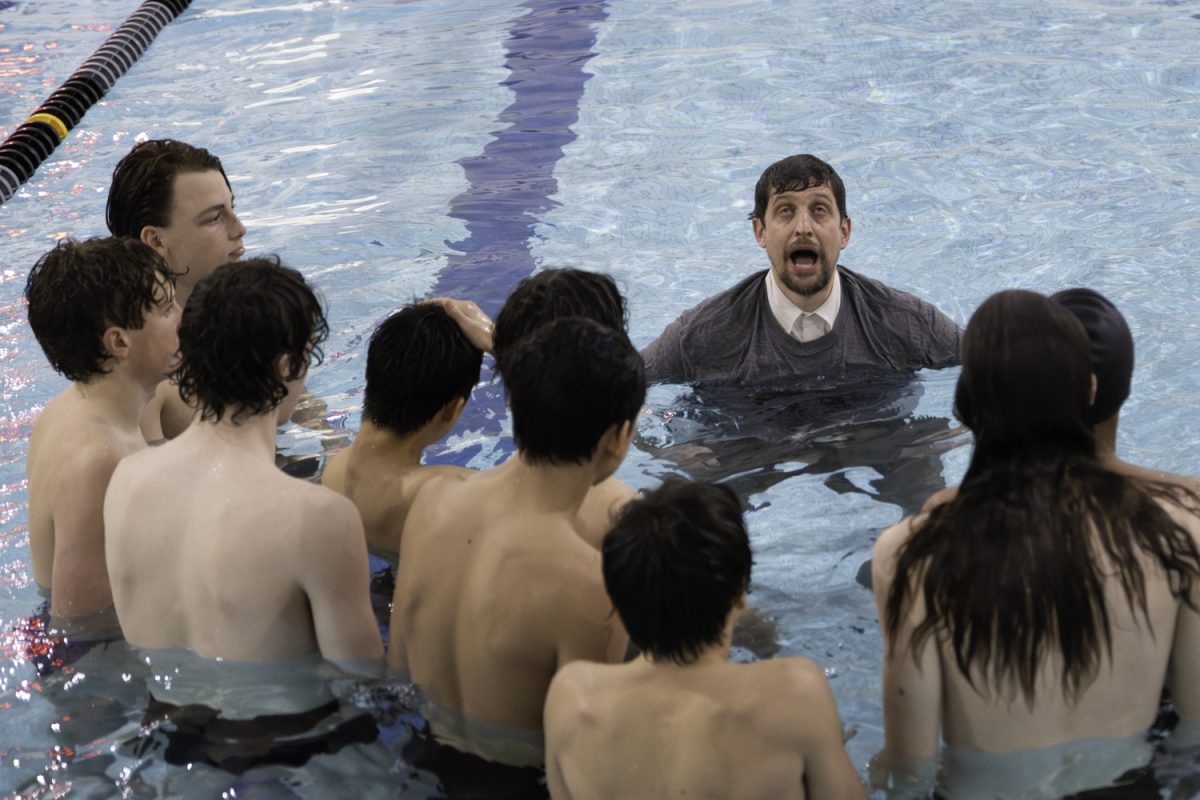 Boys+swim+team+coach+Mr.+Bryan+Ward+makes+a+silly+face+while+talking+to+the+boys+about+their+swim+performances+that+night.+