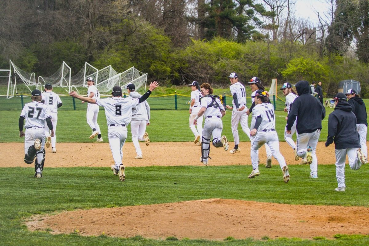 After their April 6, 2024 victory over Radnor, varsity baseball players run to the outfield to celebrate their win and listen to Coach Brian Fili's feedback on the game.