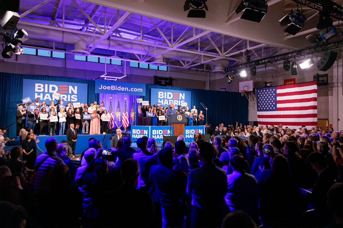 Supporters listen to President Joe Biden give his campaign speech at the middle school gym, showing the transformation of the space. 