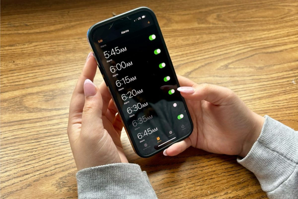 A student scrolls through multiple wake-up warning alarms. Difficulty getting out of bed can led to a necessity for alarms every few minutes.