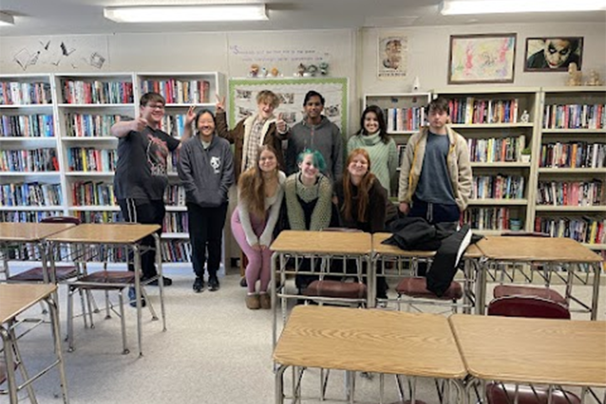 Mrs. Lattaris fall semester Creative Writing class pose for a picture together at the end of the semester. The picture is then printed and hung on a wall full of past creative writing and English classes. 