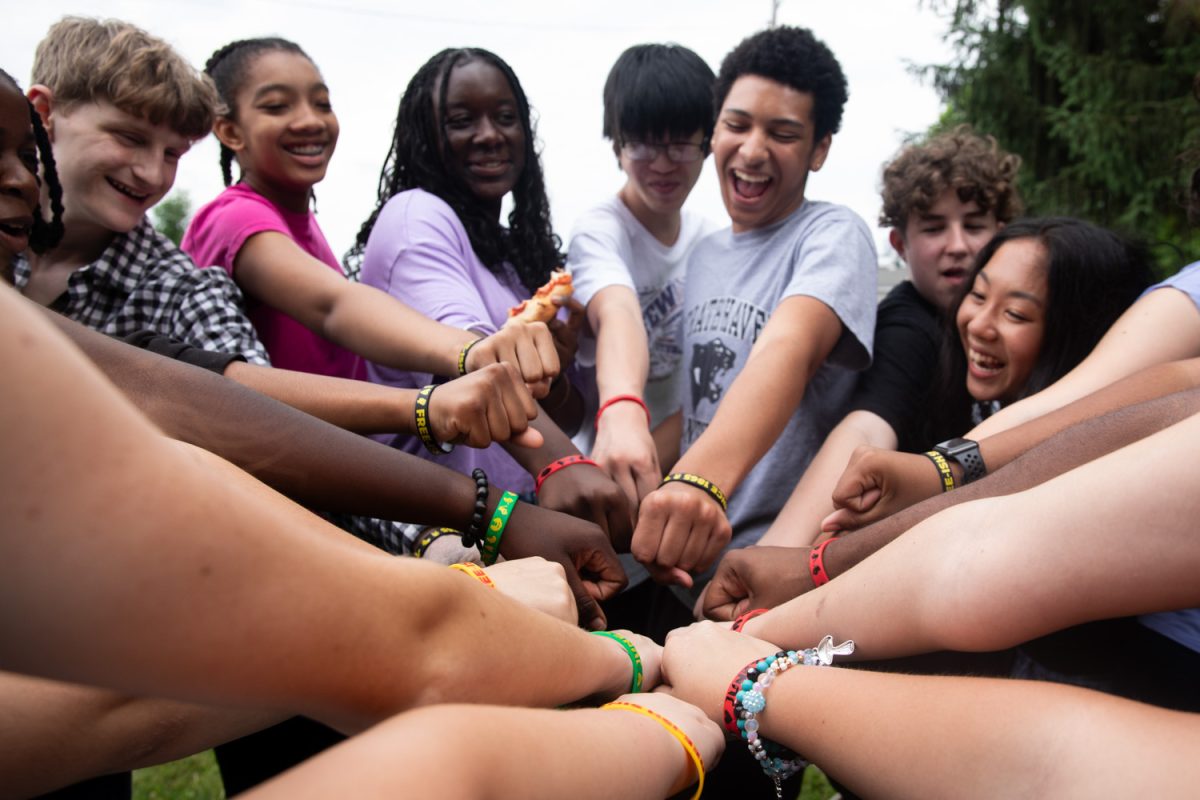 YAC members and sound crew members are all hands in as they show off their wrist bands together during the Juneteenth celebration on June 5. I was very happy with the turnout this year. Im so glad so many people came to support the event, junior Hannah Loyd said. 
