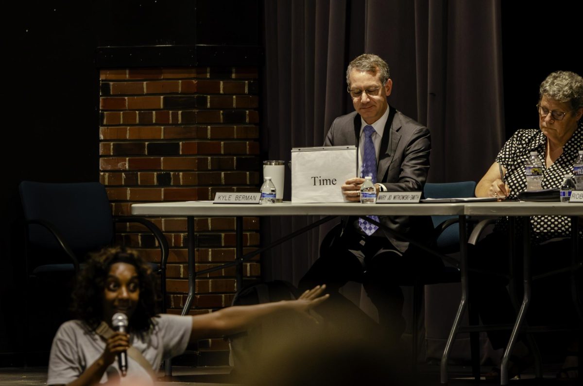 School district solicitor Mr. Kyle Berman holds up the "Time" card as parent Faith King publicly speaks at the WSSD school board meeting on the evening of Monday, June 22. The school board allowed each community member three minutes for public comment.