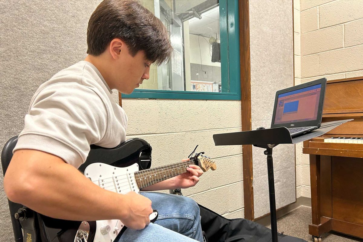 Senior Sam Le practices a song in one of the practice rooms available to students enrolled in the Introduction to Guitar class. Students played songs either individually or in groups after learning their common chords in class.