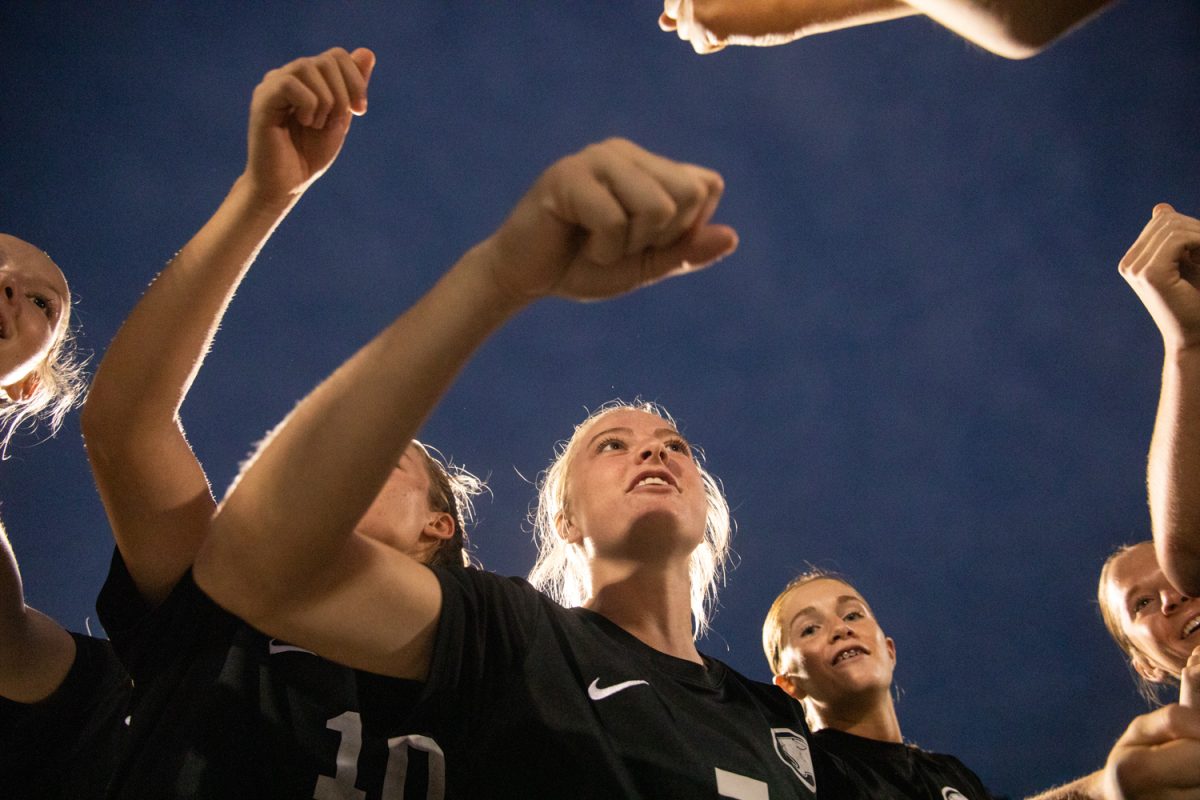 Soccer captain Annie Dignazio leads her teammates in their team huddle and chant, before the game starts. 