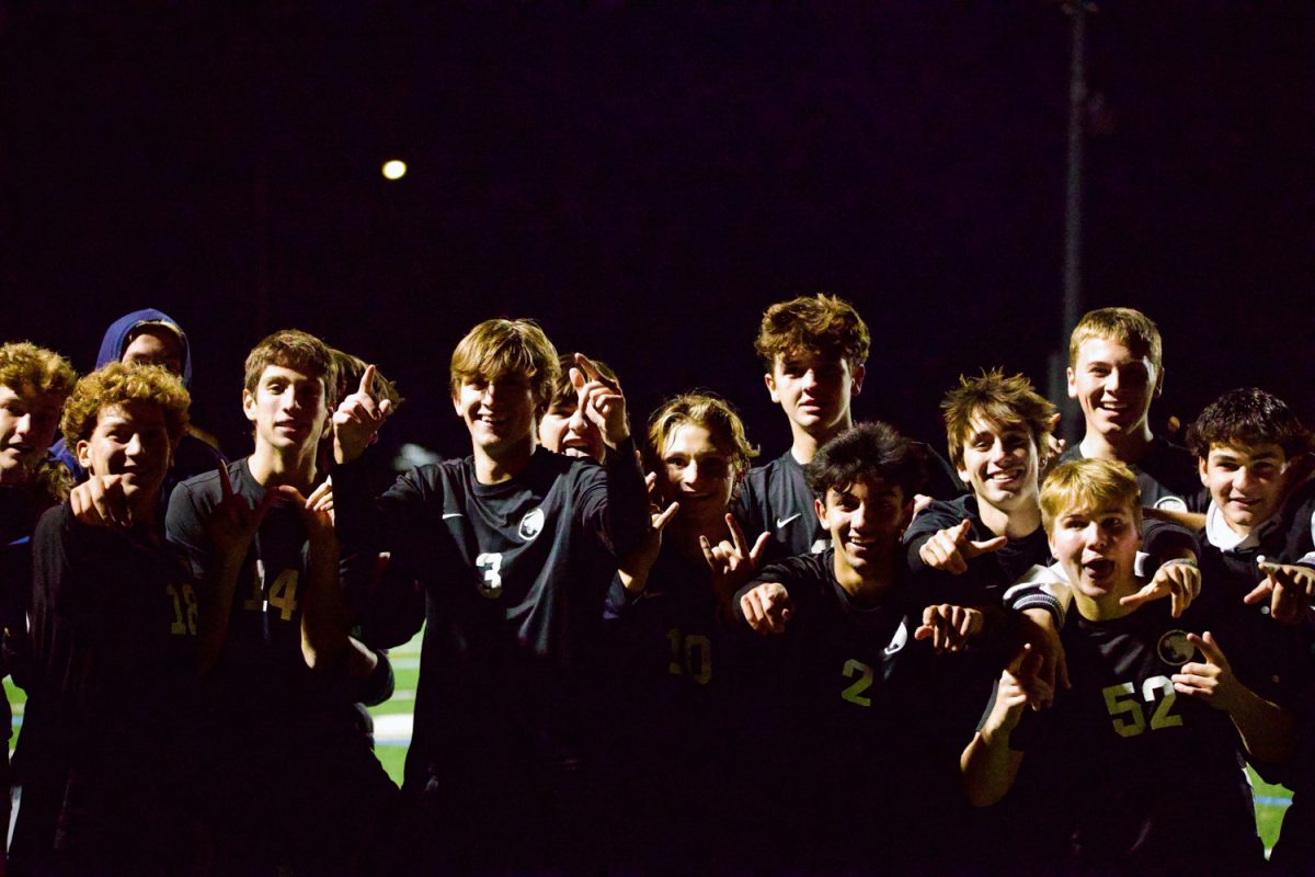 Members of the varsity boys soccer team pose for an excited smile after winning the match in overtime on October 15. 