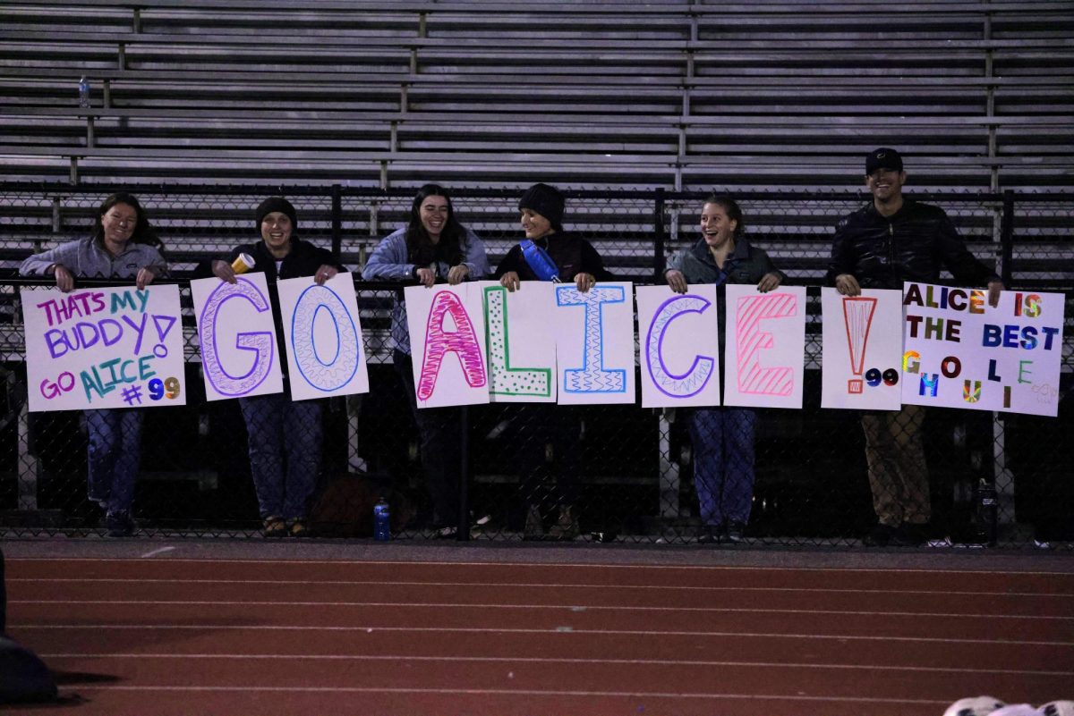 Fans hold up "GO ALICE!" signs to support freshman goalkeeper Alice Reiger after the team's successful game at King Field on October 24