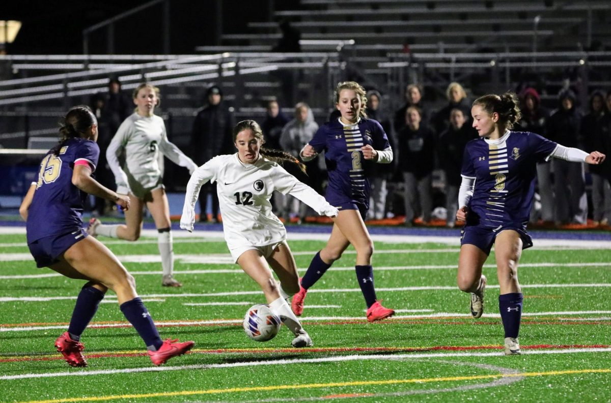 Freshman Maddie Fanning dribbles around Rustin defenders at the Semifinal game on November 12. The soccer team won 3-2 over Rustin on  Norristown High School field.