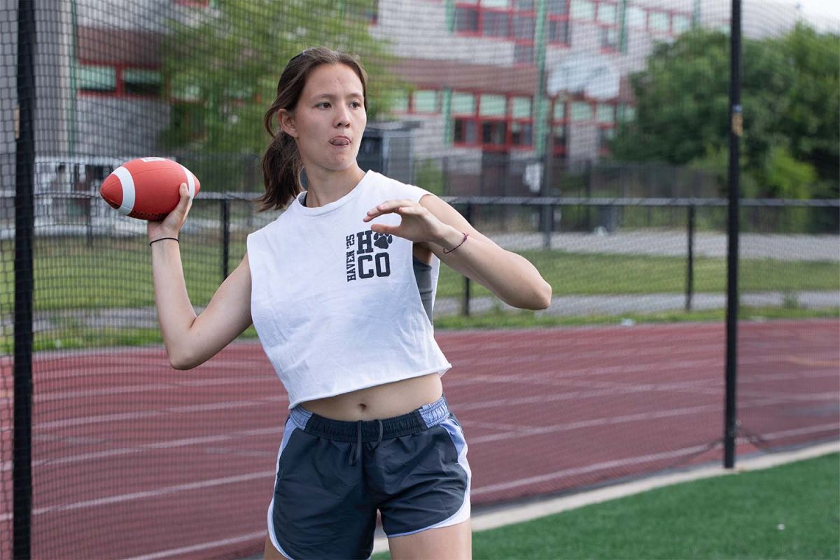 Senior (then junior) Jaden Hunter throws a football at the Powderpuff game on May 20, 2024. In this recreational game, boys varsity football players coached girls teams.