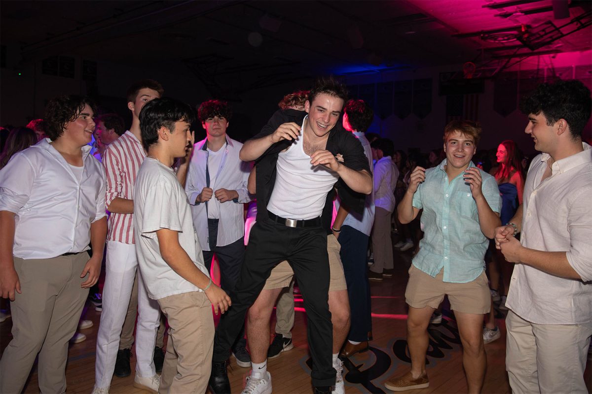 Senior Cole Mahoney smiles while being in mid-air from being thrown by one of his friends off to the side of the mosh-pit.  The first dance of the year took place Saturday, October 26th, 2024 in the gym.