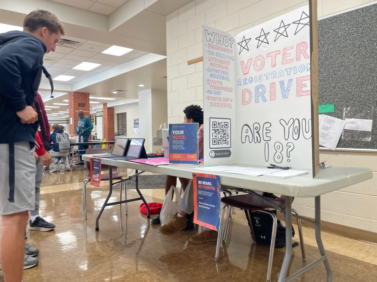 Students check out the voter registration booth at lunchtime.