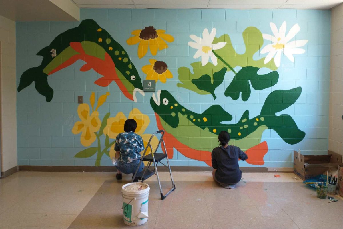 Seniors CJ Chen and Aditi Halpe paint a 
PA native plant and brook trout mural on the 4th story side-stairwell on Friday, May 31 during 5th block. Chen created a mural as a component of their independent study with a conservation nonprofit.