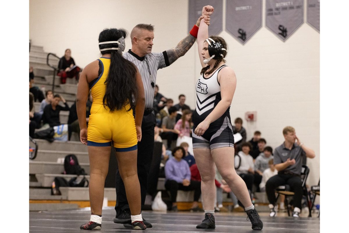 Sophomore Lane Harrington gets her hand raised after winning a match at the girls wrestling meet on December 18. Harrington pinned her opponent, a girl from Lower Merion in around 30  seconds. “I’m really happy with how many girls showed out, not just from our team, but from the youth and middle school teams to come see and support. It means a lot,” Harrington said.