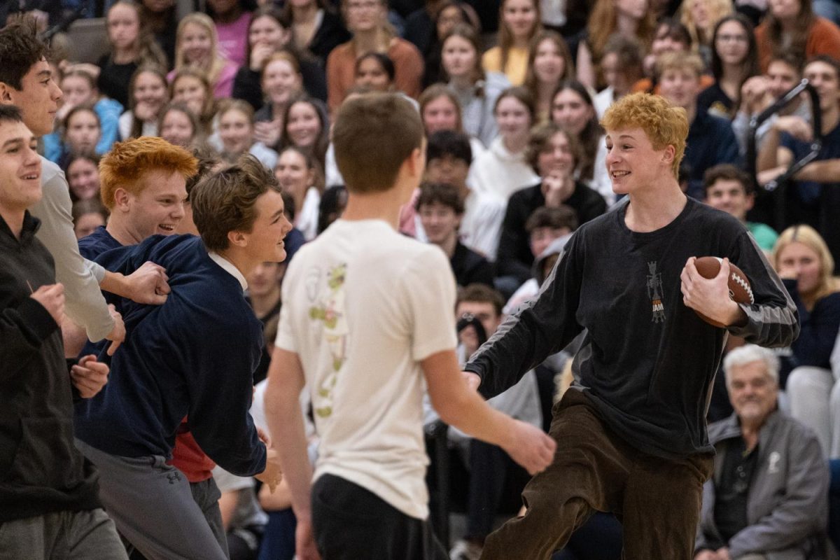 Junior Brady Nangle rushes the ball down the gym, smiling alongside his classmates during the juniors-versus-freshmen match at the Turkey Bowl on Tuesday, November 26. The school-wide assembly was revived in 2024 after the COVID-19 pandemic put the tradition on hold.