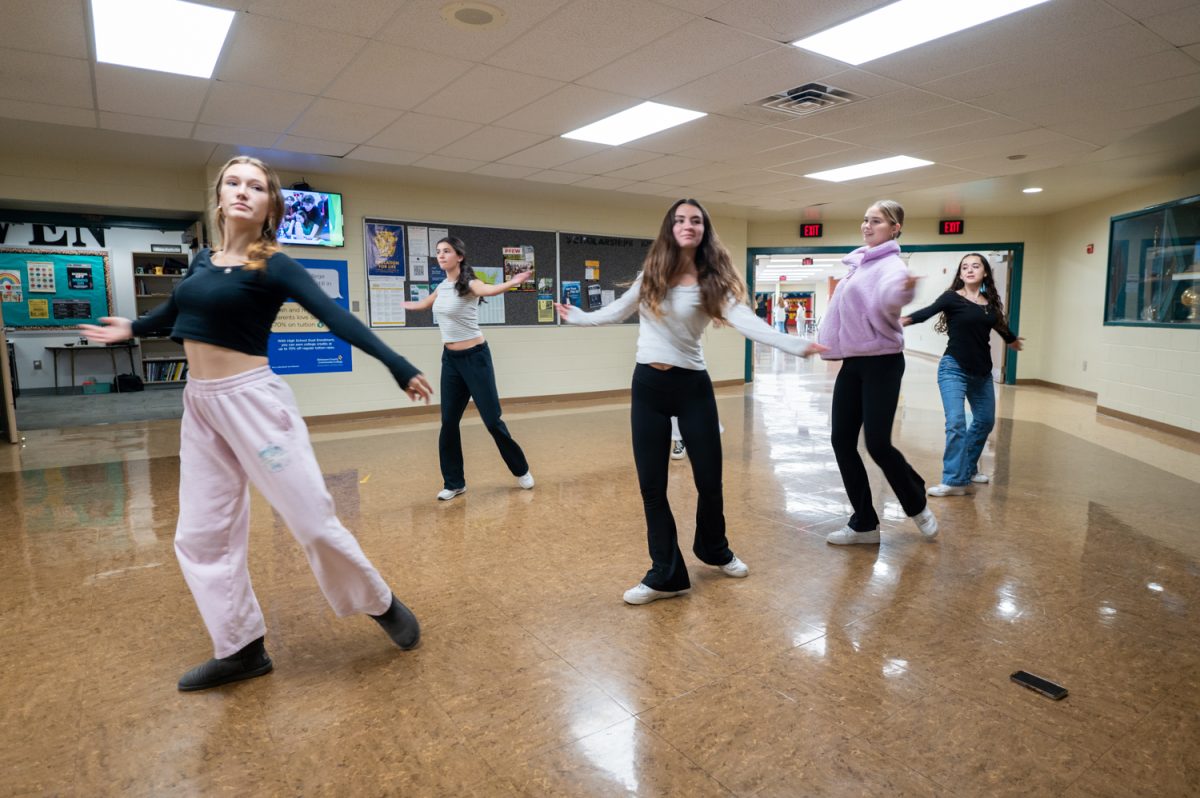 Dance Haven members rehearse choreography to the song "WILDFLOWER" by Billie Eilish on the second floor on Tuesday, December 10. Members utilize open spaces in hallways and stairwells during 5th block to prepare for the winter Dance Haven showcase.