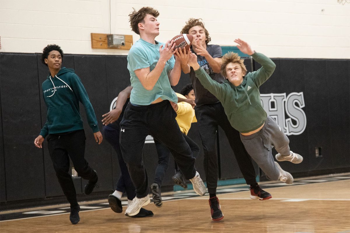 Junior Oliver Gwinn catches the ball as junior Carter Shinners dives in an attempt to block freshman Andrew Moody during the Turkey Bowl on Tuesday, November 26. The freshman team and junior team battled in the first round of the Turkey Bowl in which the juniors rose victorious.