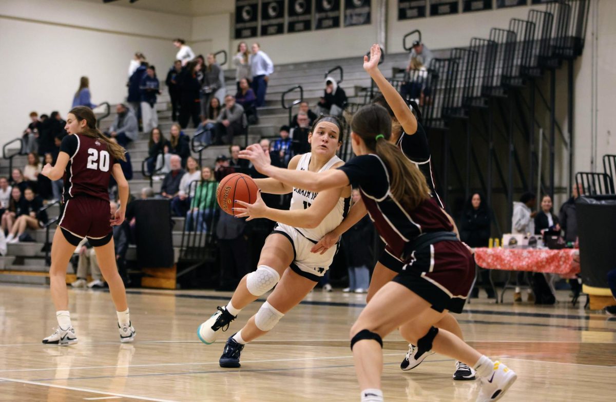 Senior power forward Olivia Voshell protects the ball while running to the basket on January 9 in the Strath Haven High School gym.