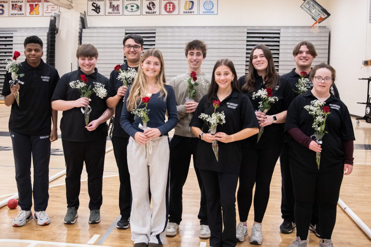 Seniors Timothy Turner, Brandon Juliano, Matteo Ventresca, Declan Zeserson, Lucy Hewitt, Owen Imbrogno, Josie Tolson, Julia Feldman, and Lara Bruno (left to right) smile for the camera with a rose in their hand in honor of senior night during the home bocce match against Academy Park on January 13. 