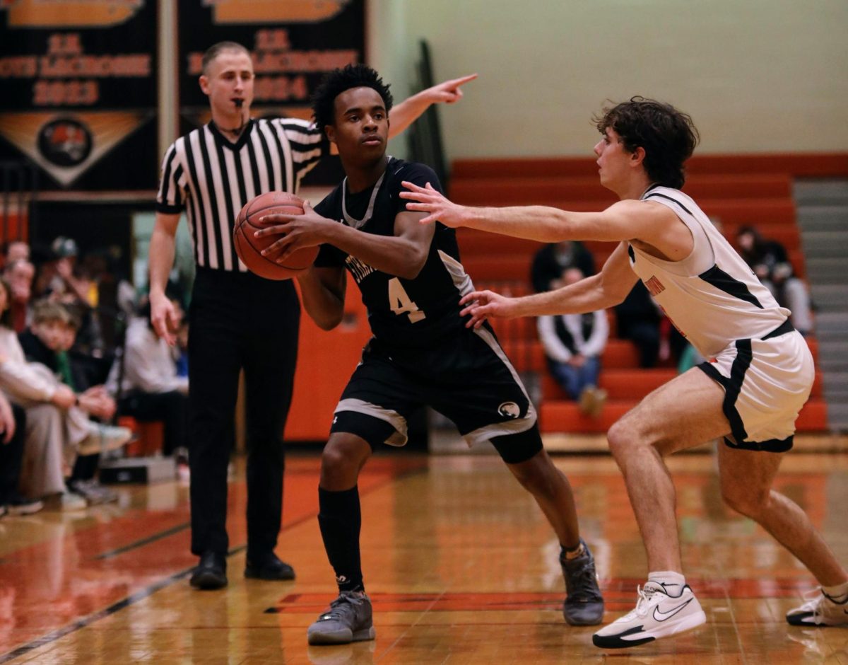 Sophomore Jalen Starr keeps the ball away from a defender, looking for a pass.