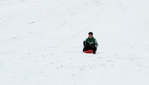 Junior Isaac Lothrop sleds outside the high school on Tuesday, January 21. That day was a final exam make-up day, meaning students who already completed their final exams had the day off.