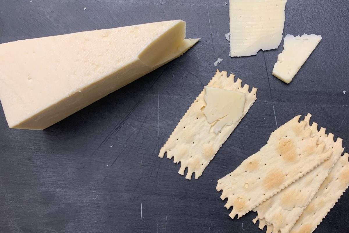 Aged Asiago on a platter. The asiago d'alleva is accompanied by crackers.