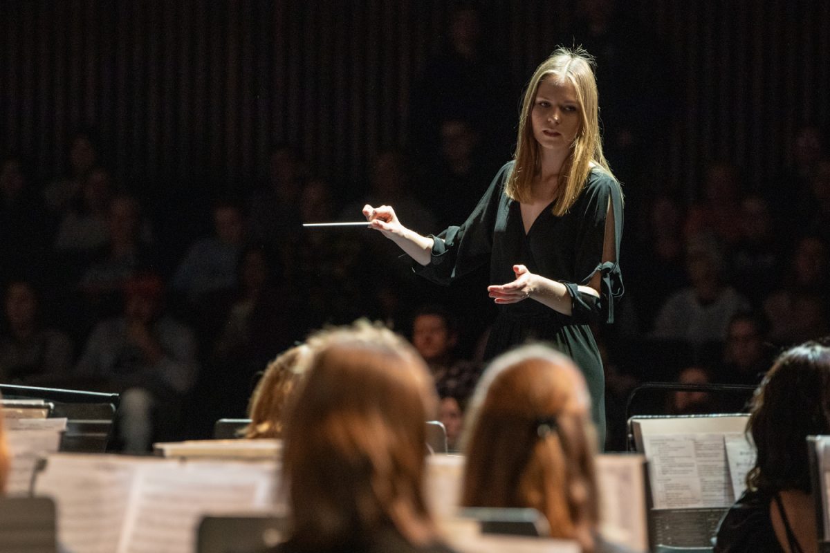 Student teacher Ms. Samantha MacFarlane conducts the wind ensemble in their piece "Caribana Afterparty" during the band and orchestra concert on March 19. The song, along with many others, followed a theme of beginnings, middles, and ends-- highlighting the beauty of the mundane, every day things. 