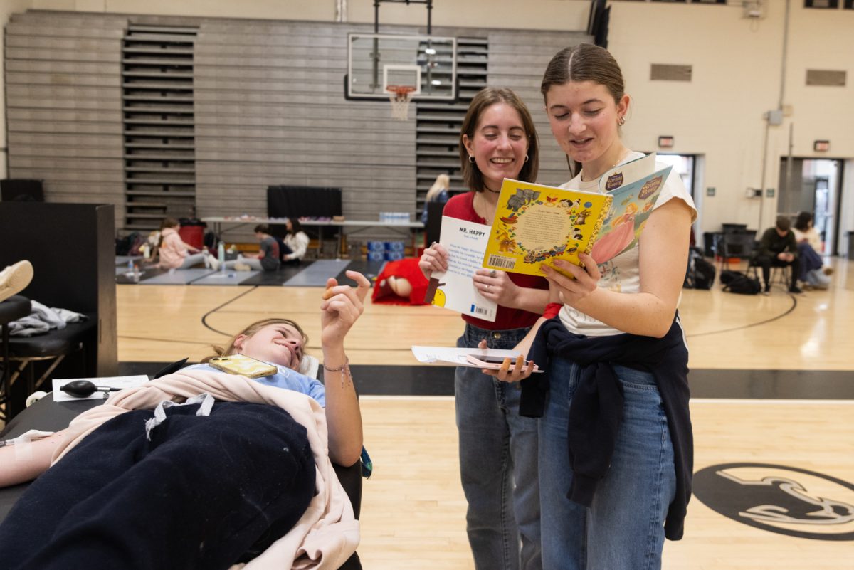 While reading to junior Keegan Mansor, junior Ainsley Sullivan reads a detail that makes Mansor and junior Josie Wieland smile.