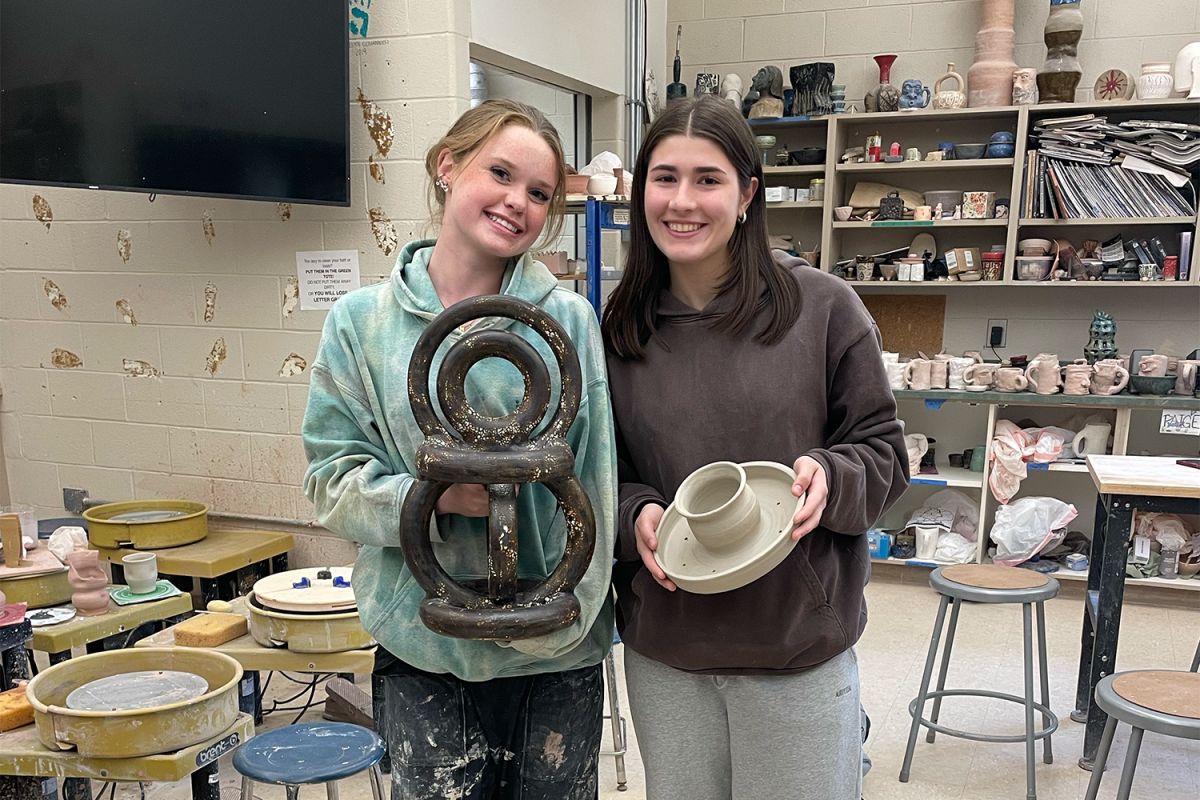 Seniors Amber Motsch and Kate Fox display some of the pieces they have made in AP Art.