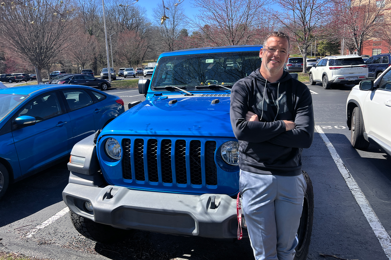 Health and physical education teacher Mr. Steve Woolery stands with his 2021 blue Jeep Gladiator on March 27.