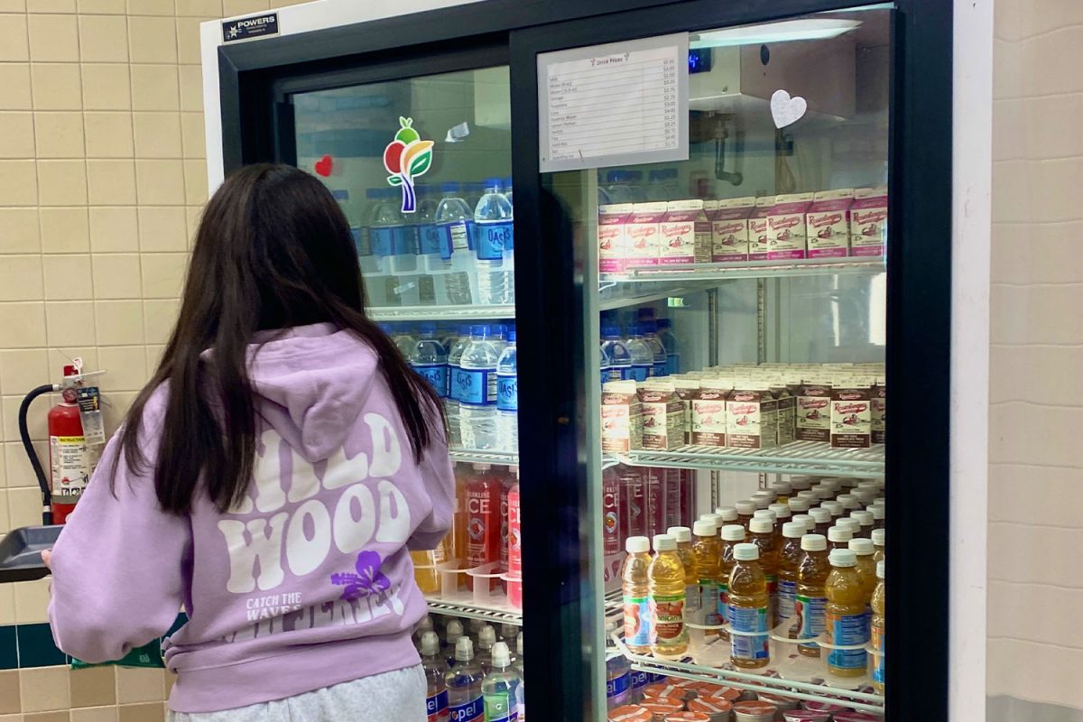 A student takes her pick from the drinks in the cafeteria cooler.