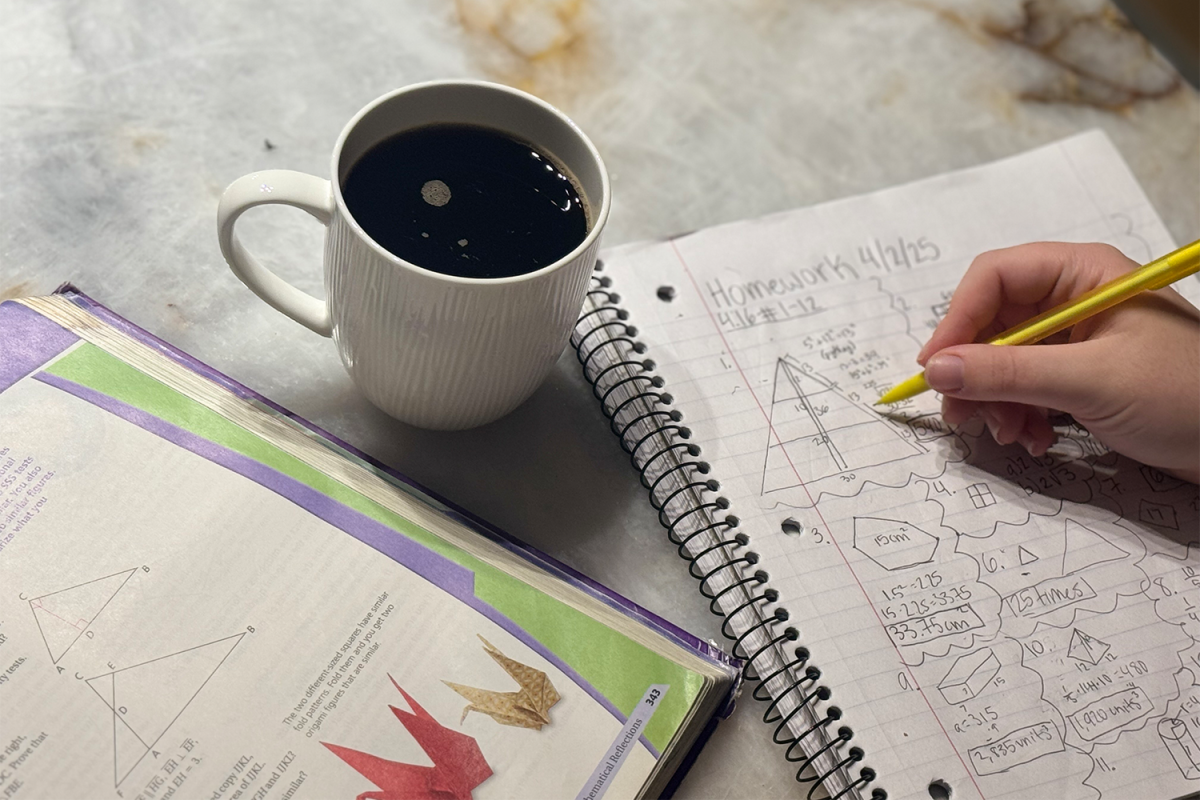ALL NIGHTER: A student sits, studying late at night with a cup of coffee to stay awake. Many students often find themselves sacrificing precious sleeping hours with studying.  