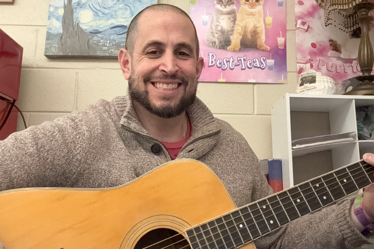 Social Studies teacher Tom Babcock poses with his guitar between classes.