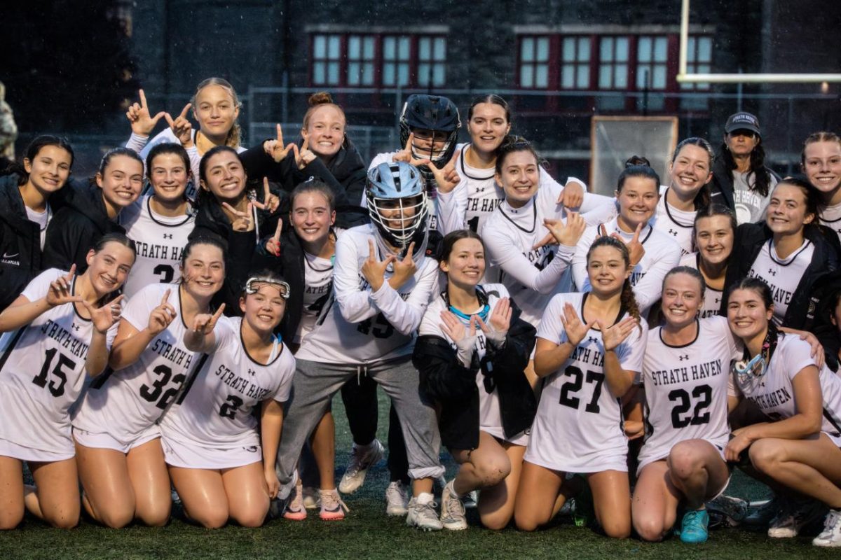 The Haven lacrosse team pose together for the camera, smiling and holding up "W" and "#1" hand signs, after winning district championships on Wednesday, May 28. The team played with a strong, adaptive offense and defense and will continue their run into states, hoping to continue winning.  