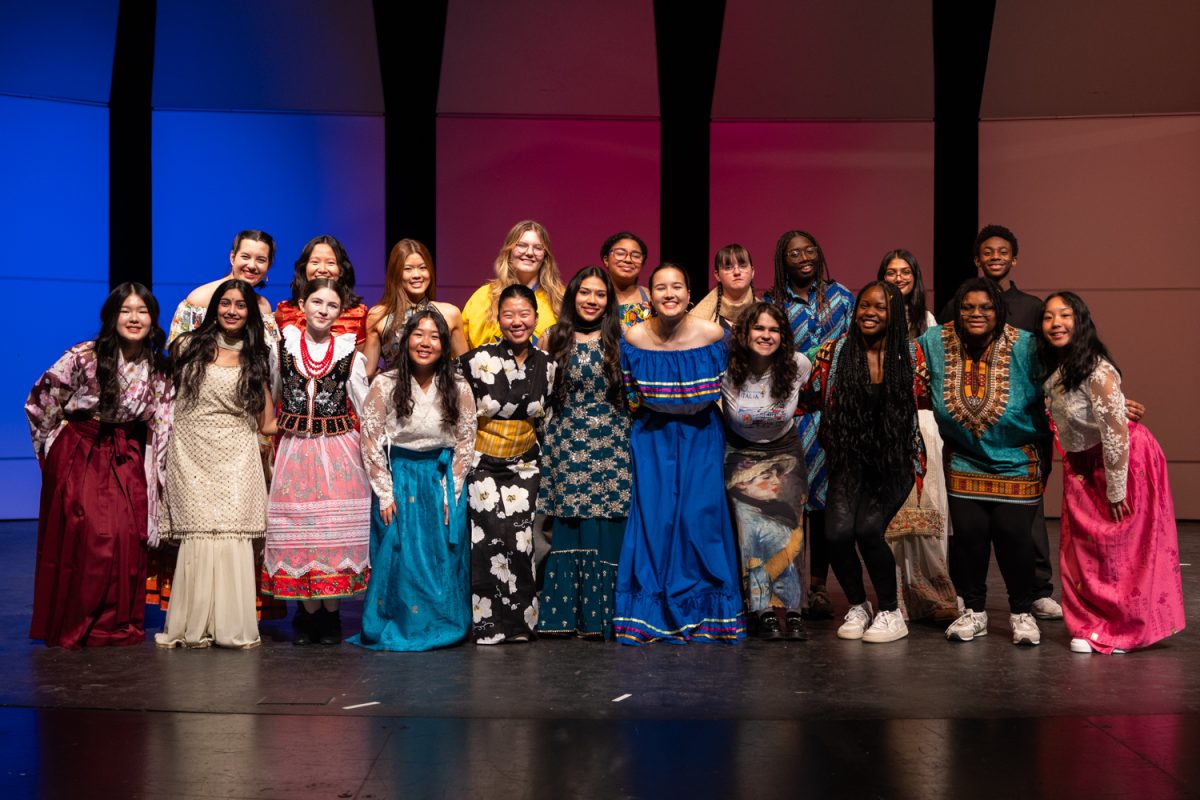 The International Day assembly performers pose and smile together at the end of the second assembly. 