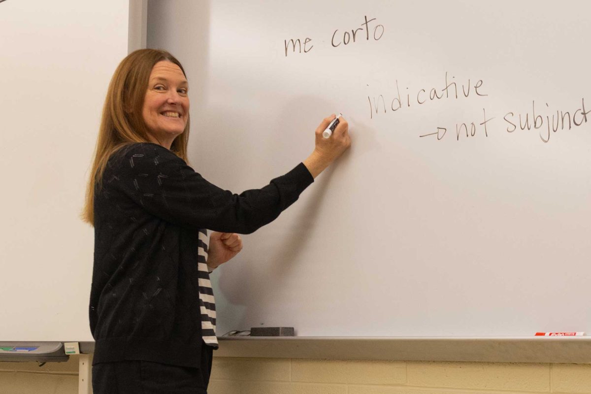 Mrs. Staci Gawne poses in front of the whiteboard, teaching her students in a Spanish 3 class.