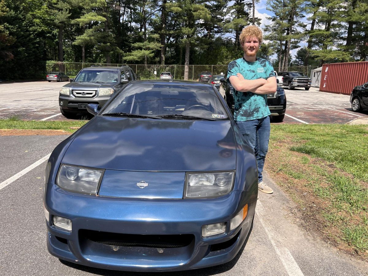 Senior Bryce Robinson poses with his blue, bullet-like, vintage 1993 Nissan 300 ZX on May 8.