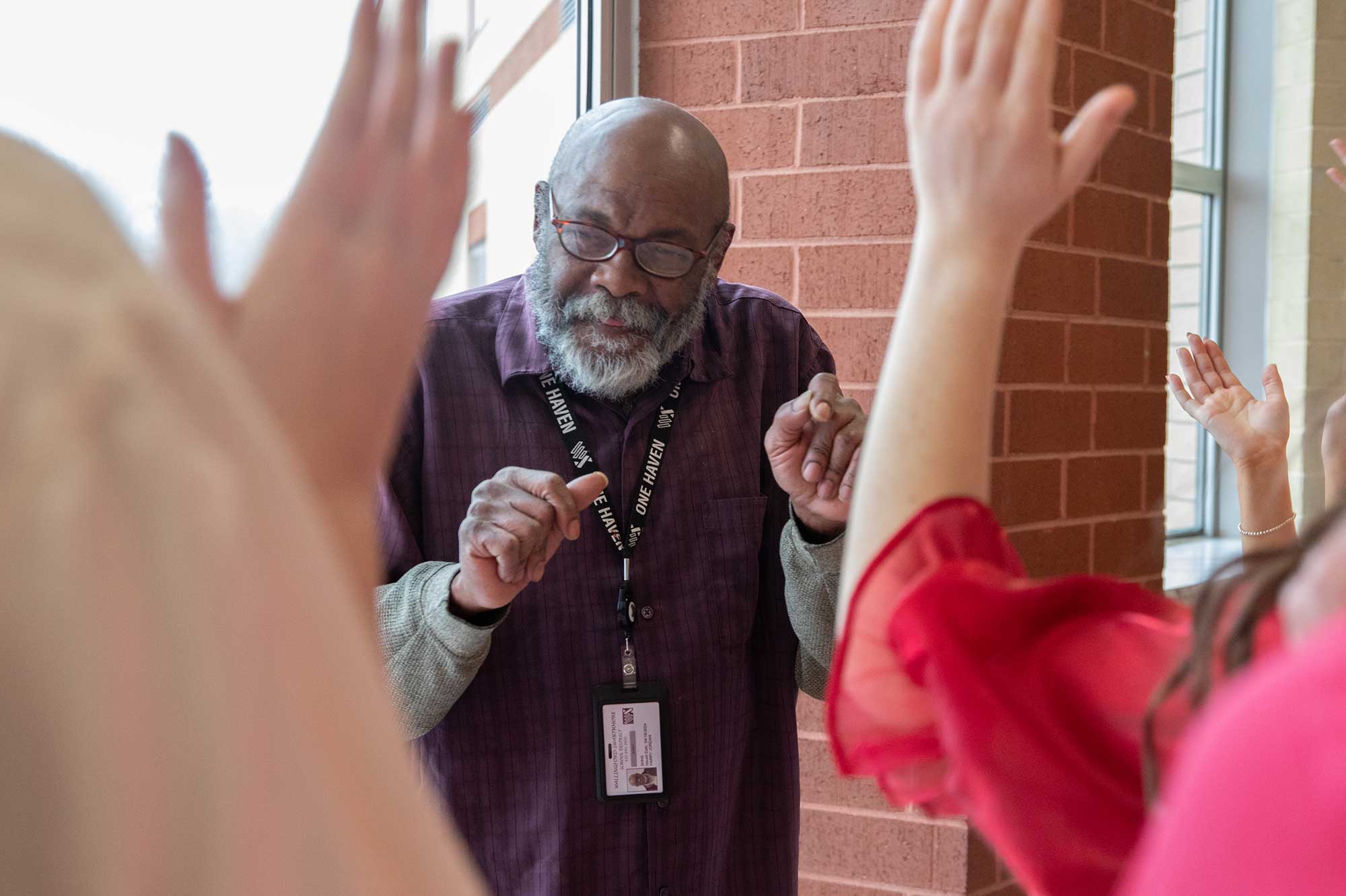 Mr. Harry Jordan dances to a singing valentine outside of the third floor hallway on Thursday, February 13. The Silvertones sopranos and altos decided to surprise Jordan by giving him a singing valentine. He thanked the group after the song ended.
