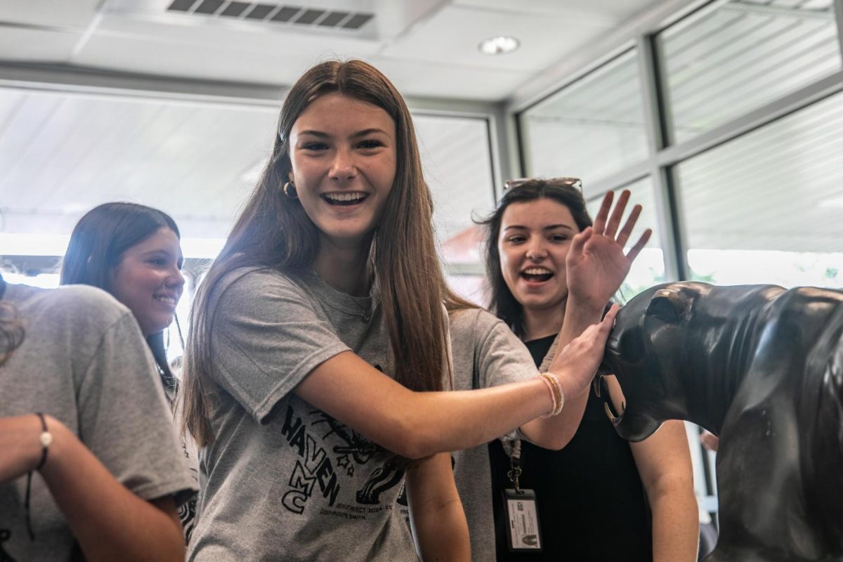 Incoming freshman Leah Noller pets the high school's panther sculpture as part of the Haven bridge crossing tradition. Staff members moved the Panther out from its usual location against the wall so it was in easy reach of the students as they entered the high school, and chanted "pet the panther! pet the panther."
