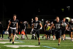 Landon Barlow (11), Quinn Kell (12), and Nick Farabaugh (12) celebrate the 44-7 victory against the Interboro Bucs on Friday, August 22. 